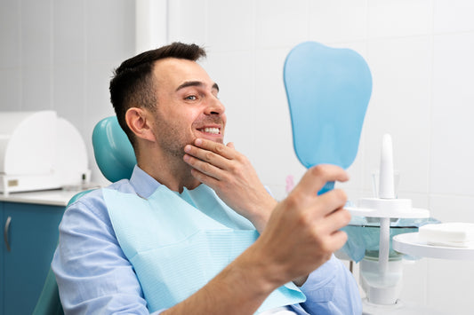 hombre mirándose al espejo antes de hacerse un blanqueamiento dental sin sensibilidad